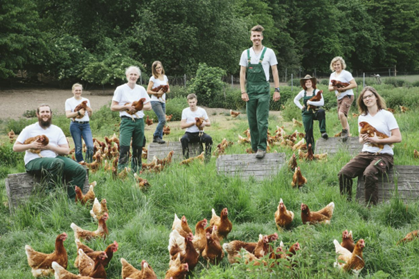 Bioland-Landwirte und ihre Hühner im Gras: Tierwohl wird bei Bioland groß geschrieben.