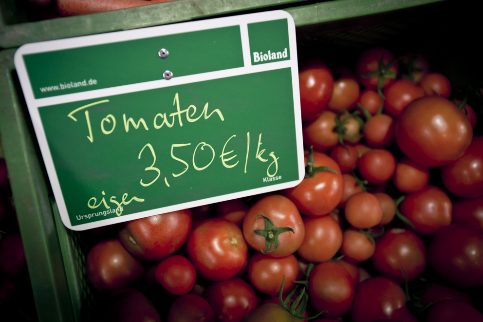 Bio Tomaten in einer Kiste die den Preis von 3,50 Euro pro Kilo anzeigt.